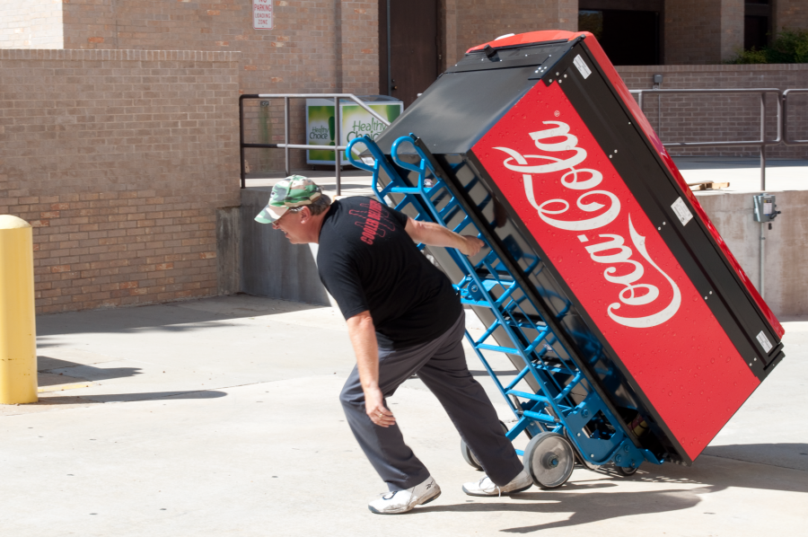 A Canteen Vending services employee wheels in a new soda machine.