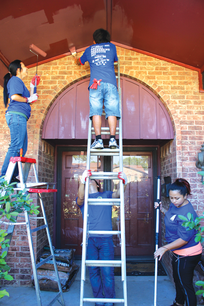 Members of the Rotaract Club paint and do yard work on a homeowner's property. The Rotaract Club and Phi Theta Kappa brought 12 students each, helping make up about 1,000 volunteers who participated on Addressing Mesquite Day. PHOTO BY ANDREA CARRIZALES/THE ET CETERA