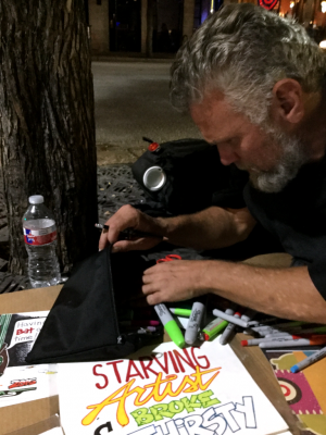 Foster looks through a bag of Sharpie markers and pens provided by Art from the Streets.