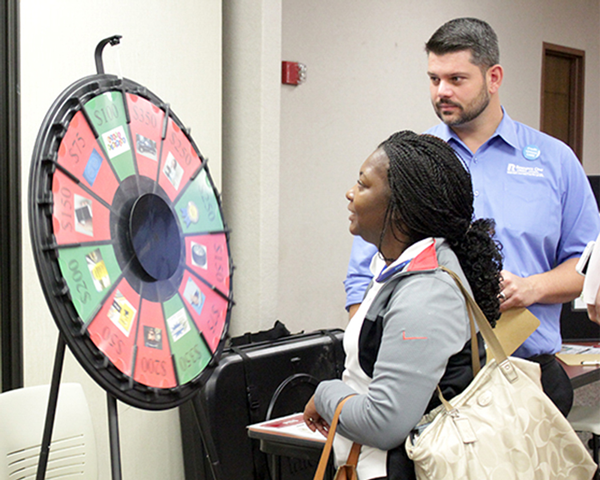 Teresha Richardson spins the “Wheel of Misfortune” at the Reality Fair. At the end of the course, the wheel simulated life’s unplanned events.
GUILLERMO MARTINEZ/THE ET CETERA
