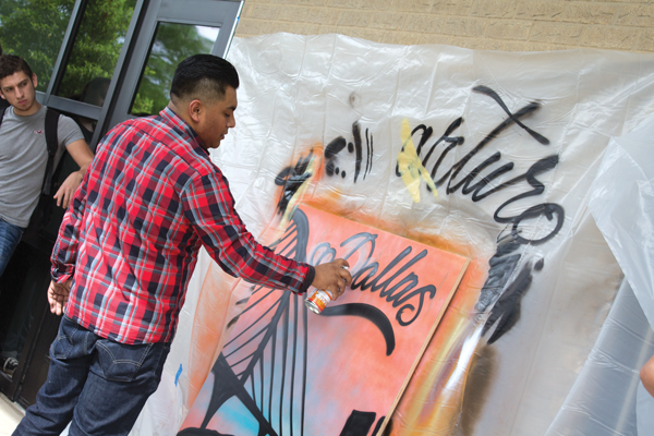 Arturo Donjuan spray-painting a piece of lauan wood April 21. PHOTO BY JASMIN JIMENEZ/THE ET CETERA.