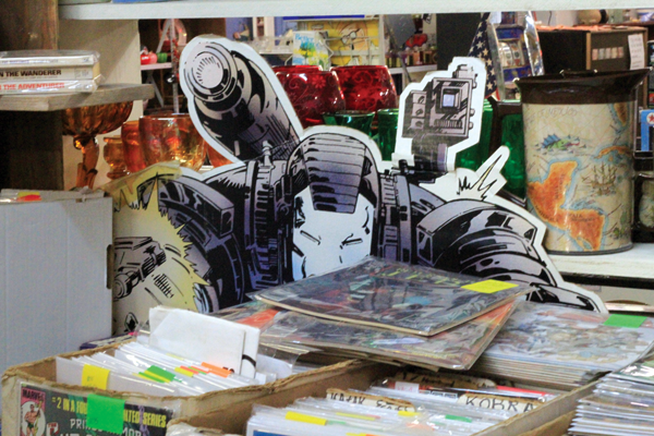 A life-size cardboard cutout hides behind boxes of comic books at East Fork Mall in Sunnyvale. Photo by Macks Prewitt/The Et Cetera.
