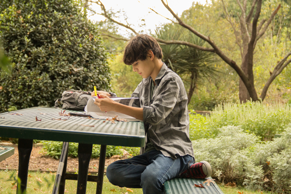 Matthew Espinosa, a 15-year-old dual credit student at Eastfield College, studies for his history class at the arboretum. Espinosa’s mother, Ruthie Espinosa, homeschools her three children still in school. Photo by James Hartley/The Et Cetera