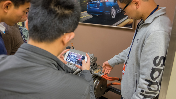 Liu Jun examines a car engine in T building. Photos by Jesus Ayala/The Et Cetera