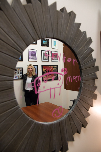 Judith Dumont poses in her office in W-building. Dumont's 5-year-old son Ryder Dumont drew on a mirror that hangs in her office. Alejandra Rosas/The Et Cetera.