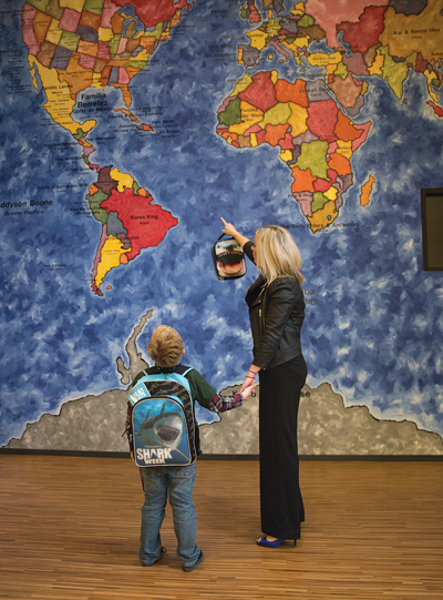 Dumont points out the United States to Ryder on a map mural. Alejandra Rosas/The Et Cetera