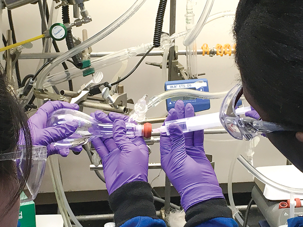 Eastfield student Vianney Sanchez, left, and University of Texas at Dallas PhD candidate Milana Thomas work on a treatment for lupus nephritis, which attacks the kidneys. Eastfield’s team placed third in the Young Women in Science Program, earning each of the four members $1,000 scholarships to UTD.  Photo courtesy of Murray Gans