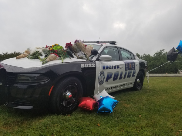 Balloons and flowers cover a police patrol car outside Santander’s station in Northeast Dallas. Josue Hernandez/The Et Cetera