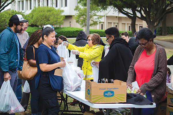 Volunteers hand out fres produce during one of the food truck visits to campus. The Et Cetera file photo.