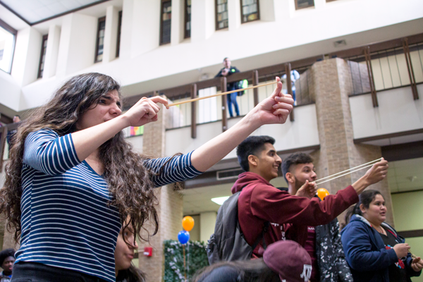 Nursing major Maurilia Vargas, 18, slings a rubber band to target a role of toilet paper. Early College High School students played a variety of games against time at the Minute to Win it event in the Hive on Jan. 25. Photo by Yesenia Alvarado/The Et Cetera