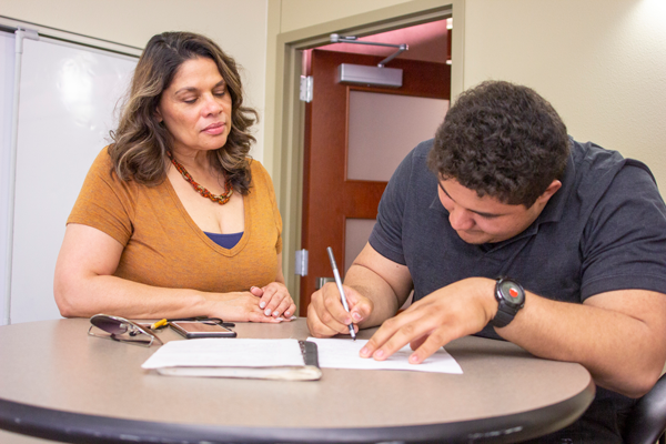 Liz Nichols assists criminal justice major Yonathan Mejia after African American studies class. Photo by Yesenia Alvardo/The Et Cetera