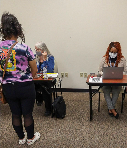 Nancy Abdo, left, helps someone register for the COVID-19 vaccine incentive in C-135 on Sept. 9. Photo by Vera DeJohnette/The Et Cetera