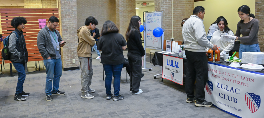 Students and faculty line up for food during the LULAC fundraiser inside the Hive.