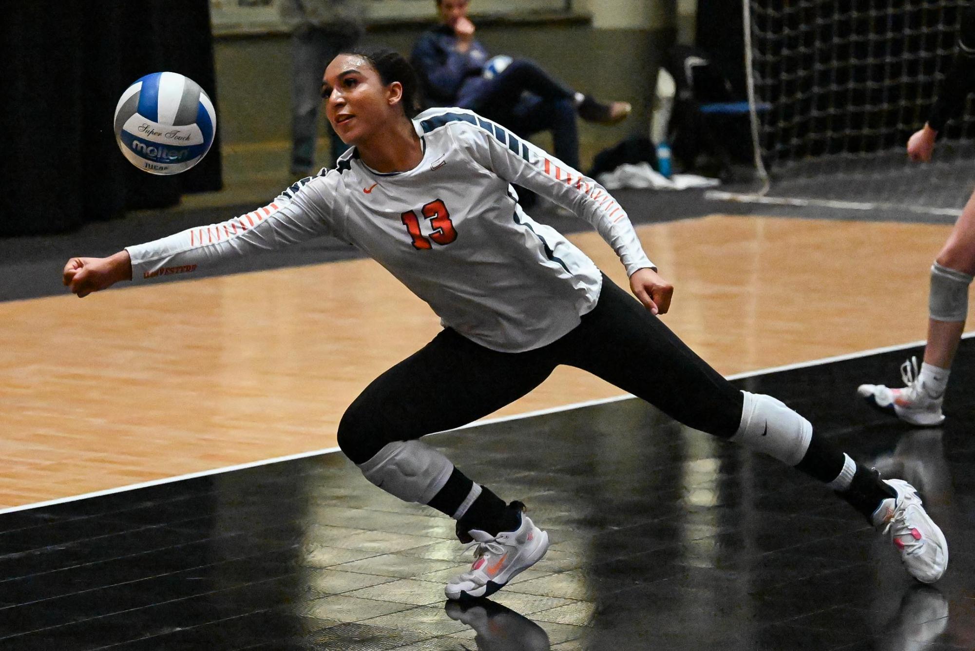 Outside hitter Azoria Davis leans to prevent an Alexandria kill.