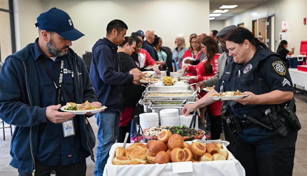 Campus police and faculty members grab food at the holiday luncheon.  