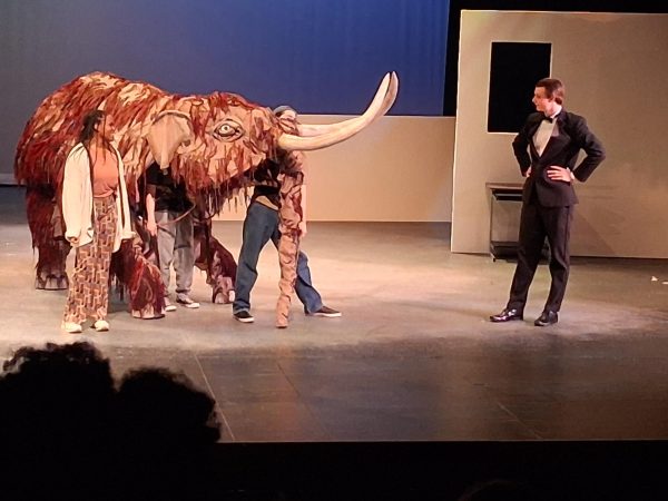 The mastodon puppet stands with student actor Jack Strahm.